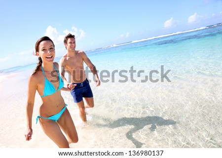 Couple running on a sandy beach