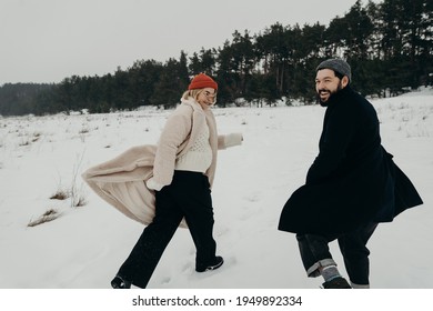 A Couple Running On A Snowy Field