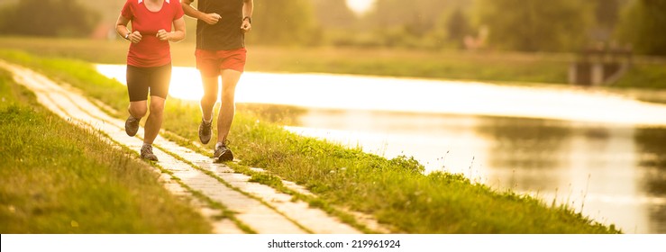 Couple Running Outdoors, At Sunset, By A River, Staying Active And Fit (color Toned Image)