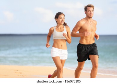 Couple Running. Sport Runners Jogging On Beach Working Out Smiling Happy. Fit Male Fitness Model And Attractive Female Jogger. Multiracial Group, Asian Woman And Caucasian Man.