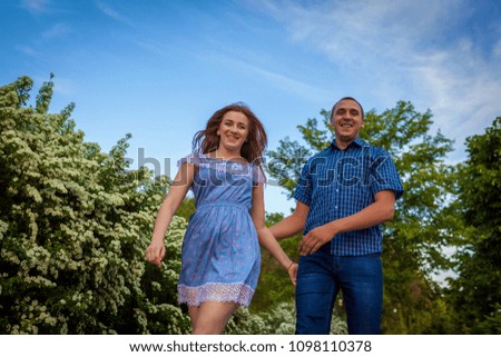 Couple running in spring blossoming park. Young man and woman having fun at sunset.