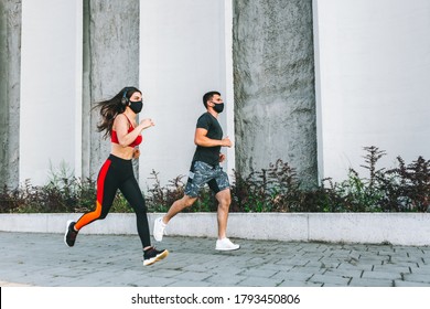 Couple running in an urban environment wearing protective masks - Powered by Shutterstock