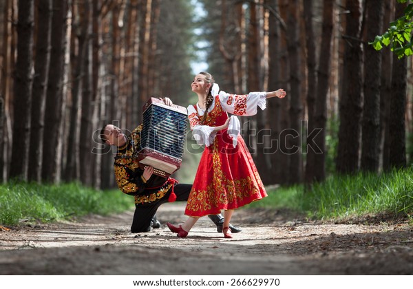 Couple in\
russian traditional dress in the\
forest