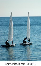 a couple of sail dinghies out in the ocean