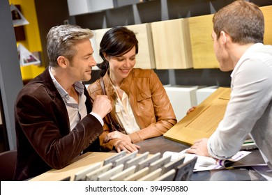 Couple with salesman in kitchen furniture store