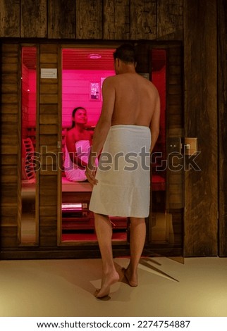 couple in a sauna, men and woman in bathrobe visiting a hot infrared sauna indoor