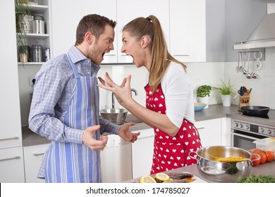 Couple screaming at each other at kitchen - stress.