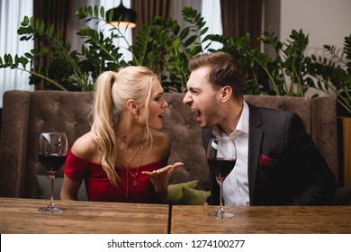couple screaming at each other while sitting in restaurant 