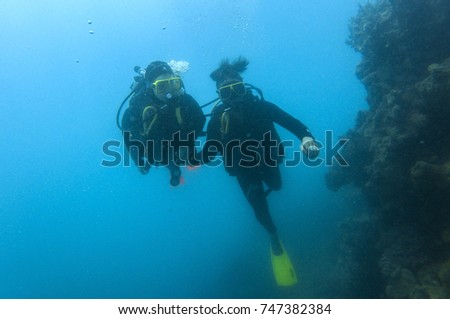 Couple scuba diving in great barrier reef 