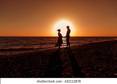 Couple At The Sea At Sunset