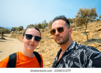 Couple Selfie With Orange Blouse Wearing Sunglasses and Backpack Hiking in Hot Summer Day in Thassos Greece - Powered by Shutterstock