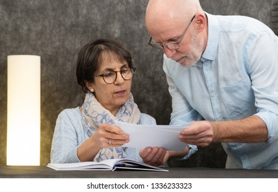 A Couple Of Senior Reading Mail At Home