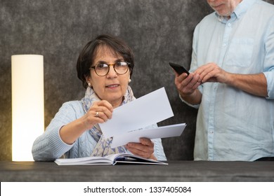 A Couple Of Senior Reading Mail At Home