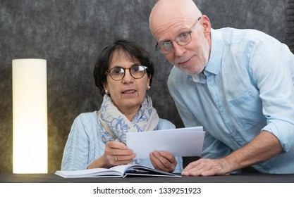 A Couple Of Senior Reading Mail At Home