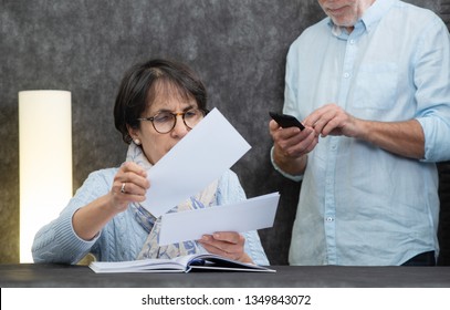 A Couple Of Senior Reading Mail At Home