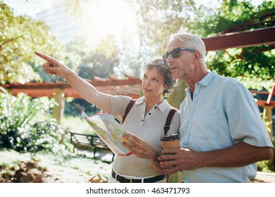 Couple of senior tourists using a city guide searching locations and pointing - Powered by Shutterstock