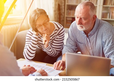 Couple of seniors getting advice on retirement and retirement planning from financial advisor at home - Shutterstock ID 2152505867