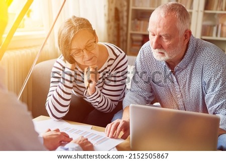 Couple of seniors getting advice on retirement and retirement planning from financial advisor at home