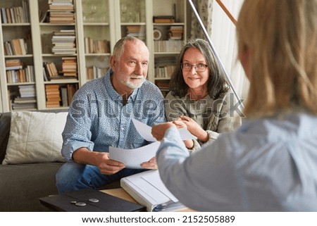 Couple of seniors getting advice on retirement and care from a senior counselor or social worker