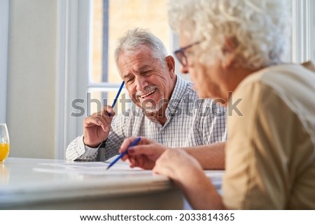 Couple of seniors has fun solving puzzles as a memory training against Alzheimer's and dementia Foto stock © 