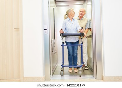 Couple Of Seniors With Rollator In The Elevator In A Hospital Or Nursing Home