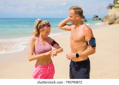 Couple Setting Devices Before Workout On The Beach