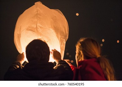 A Couple Is Setting Free A Sky Lantern 