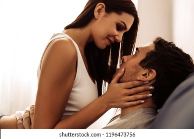 Couple. Sex. Love. Young Woman Is Touching Man's Face And Looking At His Lips, Lying On Bed At Home