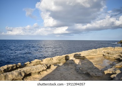 Couple shadow on a rocky shore with sea background - Powered by Shutterstock