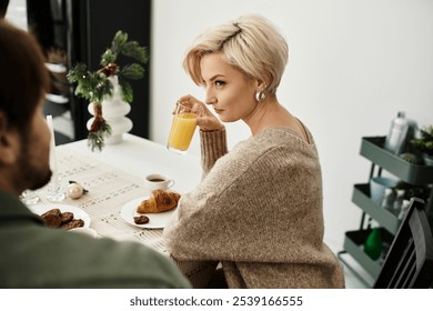 A couple shares a tender breakfast moment with orange juice and pastries in their home. - Powered by Shutterstock