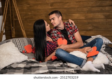 Couple sharing a romantic moment on a cozy bed with heart decorations. A couple enjoys each other’s company on a cozy bed - Powered by Shutterstock