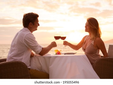 Couple Sharing Romantic Sunset Dinner On The Beach