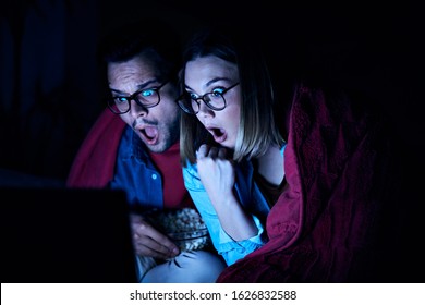 Couple shocked watching horror movie during movie night st home - Powered by Shutterstock