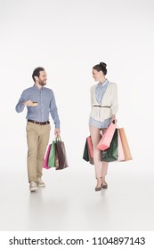couple with shopping bags and credit card looking at each other isolated on white - Shutterstock ID 1104897143