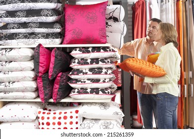 Couple Shopping For Cushions In Department Store, Side View