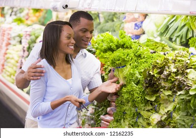 Couple shopping in supermarket produce department - Powered by Shutterstock