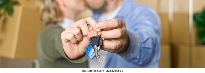 Couple showing keys to new apartment. real estate mortgage, loan concept. moving in new house. Young smiling couple holding their new house keys. first own apartment or house. - Shutterstock ID 2258260531