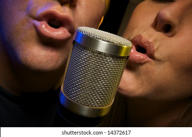 Couple Singing Duet At Condenser Microphone.