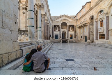 A couple sits on the steps in front of the Diocletian's palace in Split, Croatia, in the morning with no tourists.