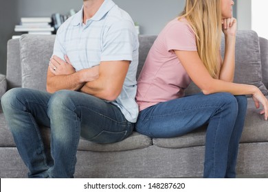 Couple Sitting Back To Back After A Fight On The Sofa In Sitting Room At Home