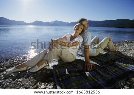 Couple sitting by lake in Germany
