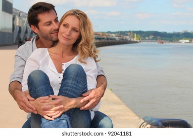 Couple sitting by the river in Bordeaux, France - Powered by Shutterstock