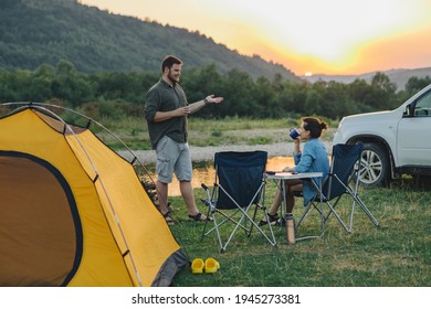 couple sitting in camp chairs looking at sunset above river in mountains. hiking concept. - Powered by Shutterstock