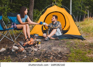 Couple Sitting At Camping Site Talking Drinking Hot Tea