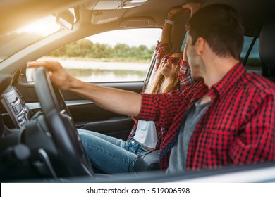 Couple Sitting In The Car Listening To Music And Having Fun. Enjoy A Fun Journey