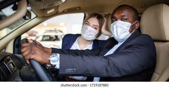 Couple Sitting In A Car Mask Wearing Medical Masks Leaving A City During A Pandemic