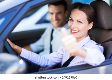 Couple Sitting In Car With Thumbs Up 