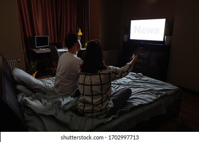 Couple Sitting In Dark Room Watching TV