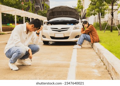 Couple sitting with headaches from boredom wasting time togethe having problems with the engine not starting parked on the side of the road unable to do anything : Car inspection before use concept. - Powered by Shutterstock