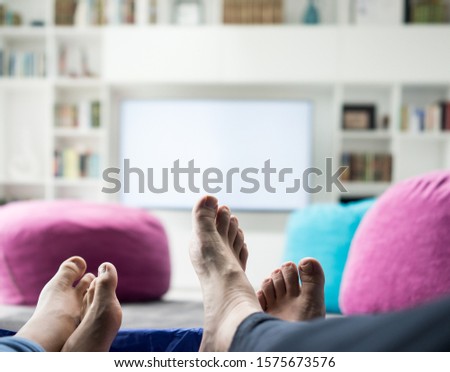 Couple sitting in home tent watching tv